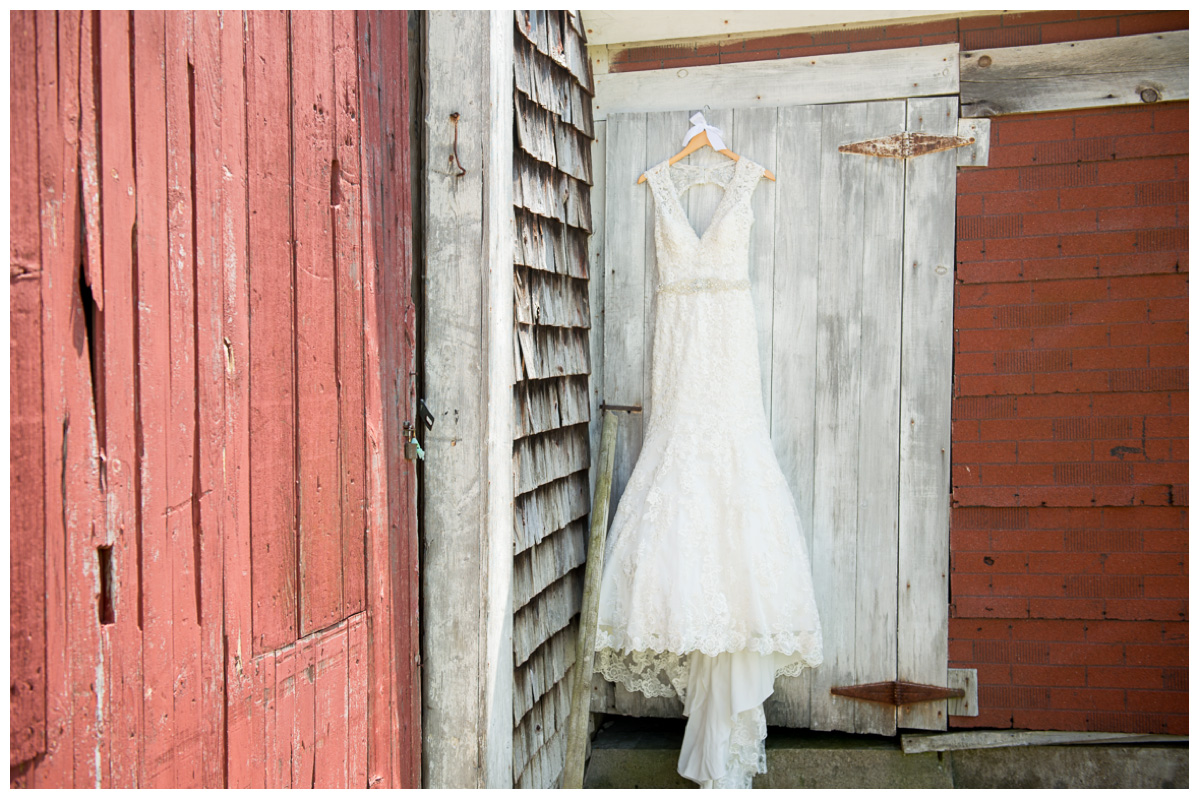 wedding dress hanging on barn 