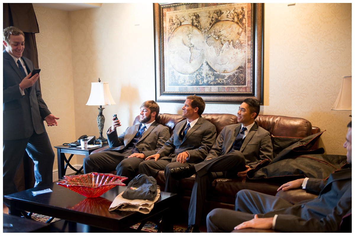 groomsmen sitting in hotel room waiting for wedding