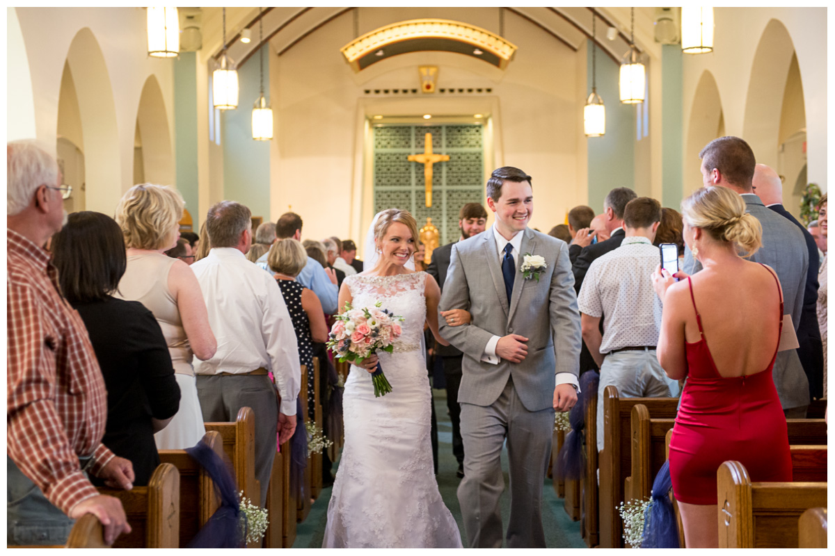 excited married couple walking out of church