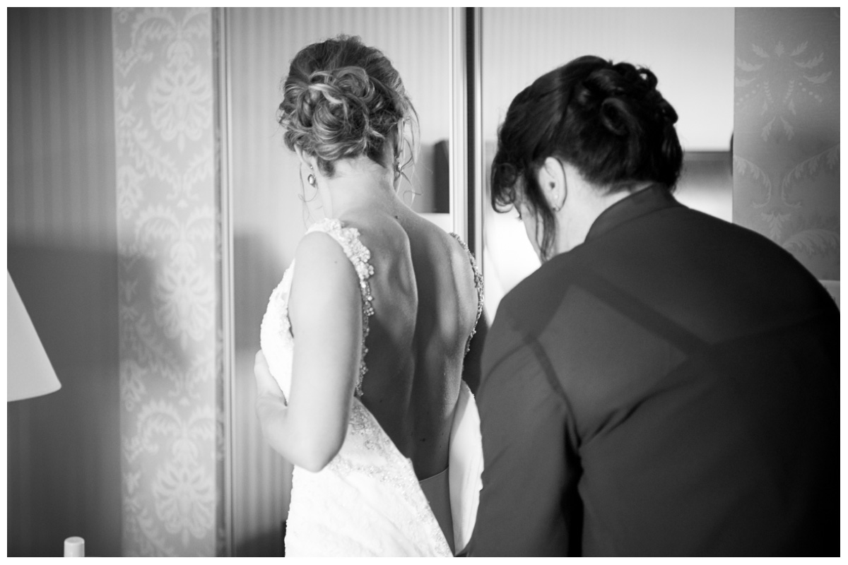 photo of mom helping daughter into wedding gown