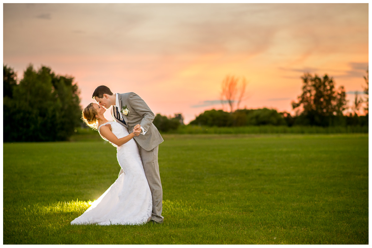 bride and groom at sunset kissing