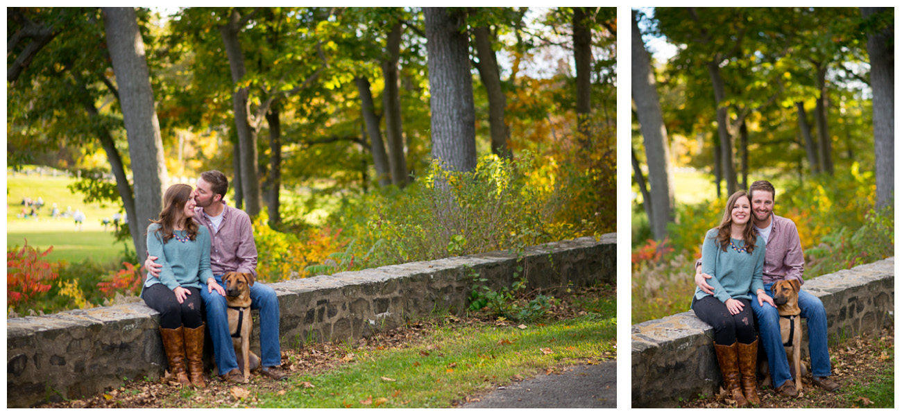 couple sitting on rock wall in fort william's park with dog