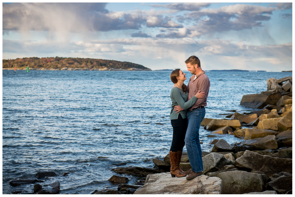 joyful couple on rocks next to the ocean