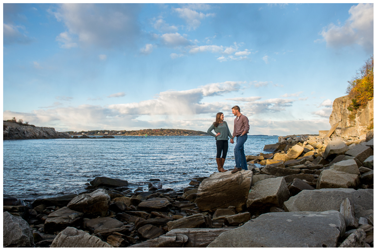 couple holding hands on rock beach in Portland