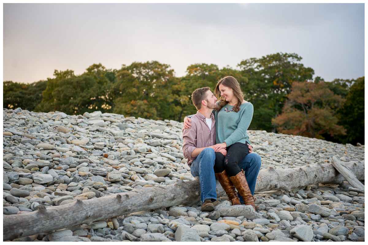 passionate couple sitting on beach for engagement photos