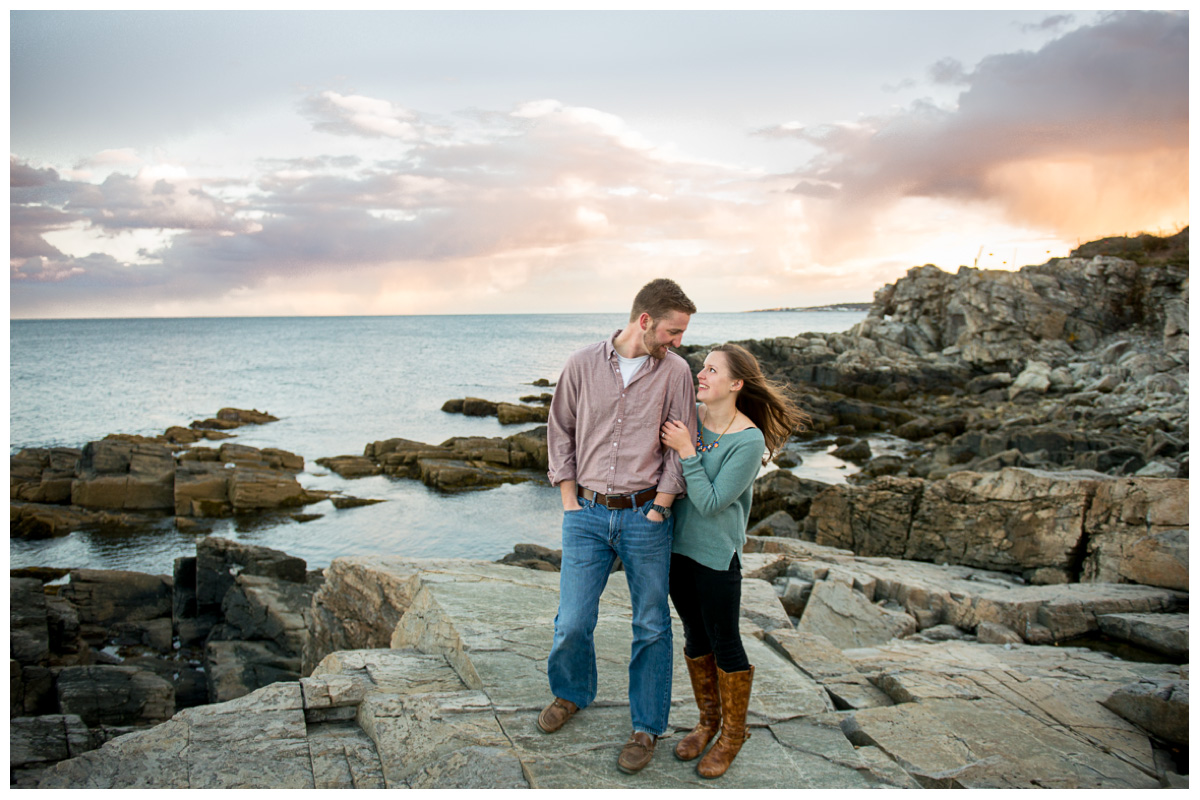 couple looking at each other during engagement photos at sunset on the beach in Maine
