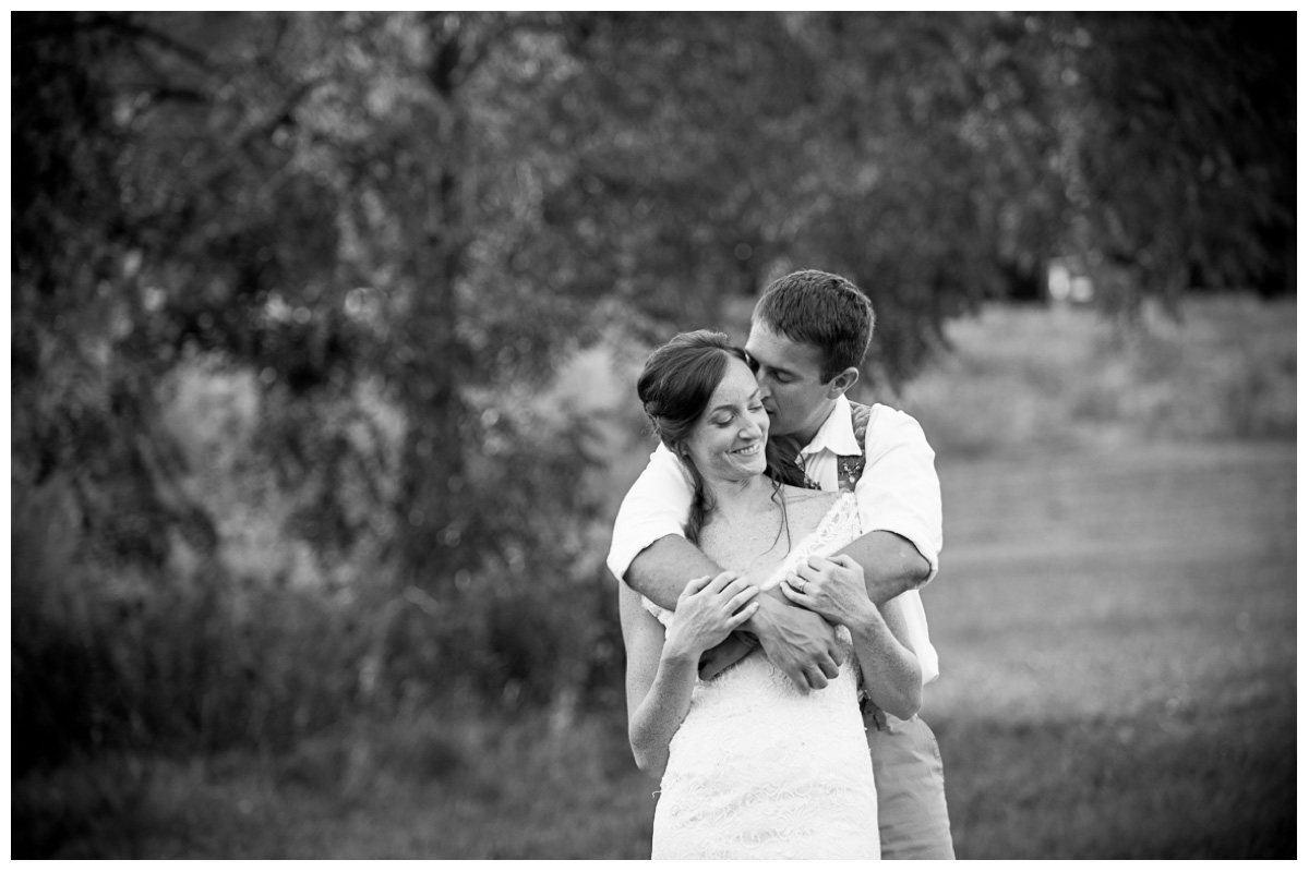 black and white photo of groom kissing bride