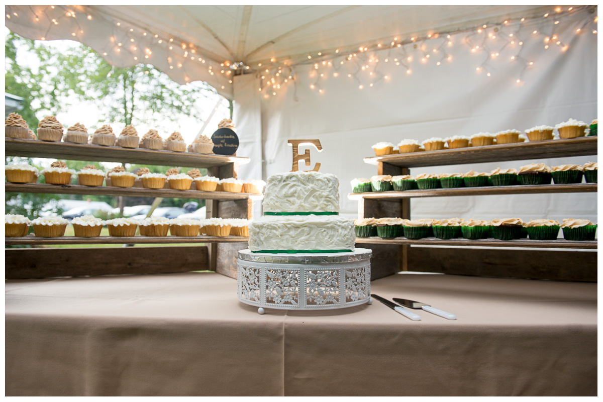 green and white wedding cake with cupcakes