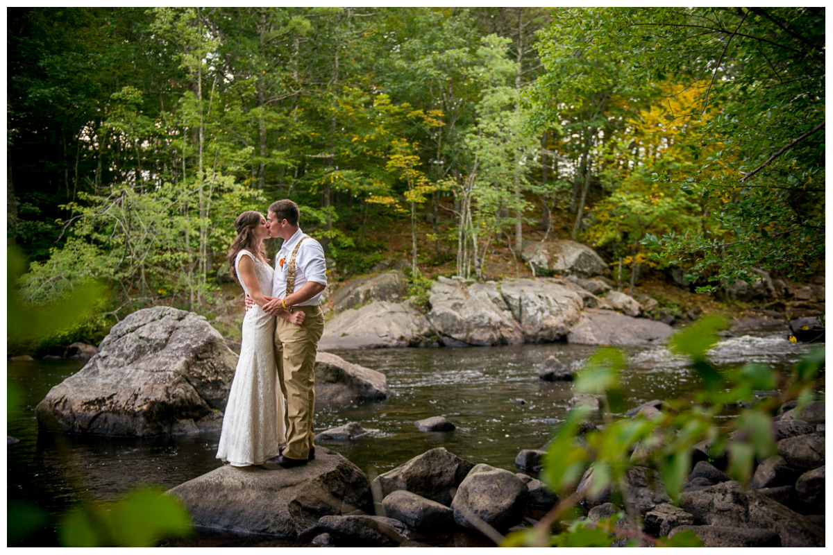 adventurous couple kissing in new hampshire river