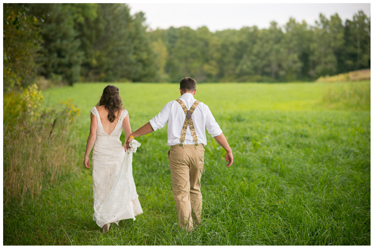 bride and groom walking in tall green grass