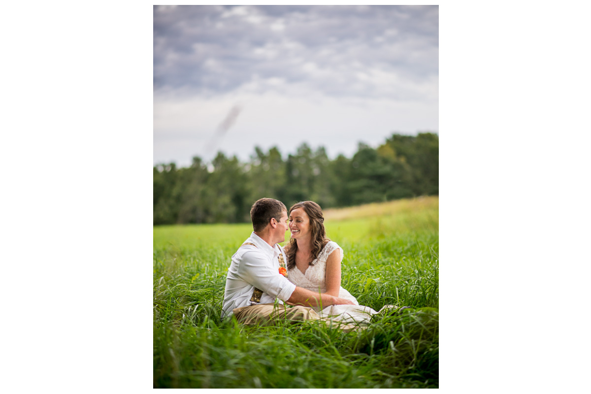 bride smiling at groom while in field at sunset