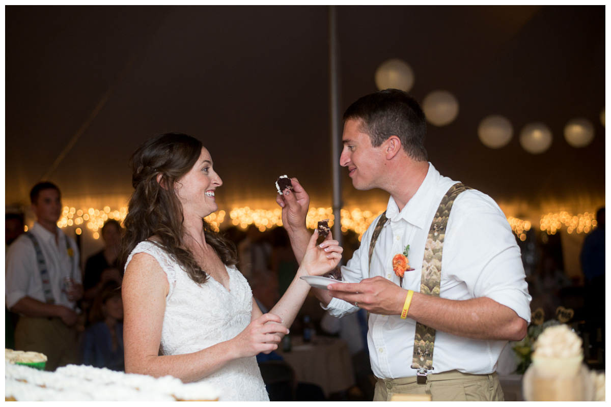 bride and groom feeding each other cake during wedding reception