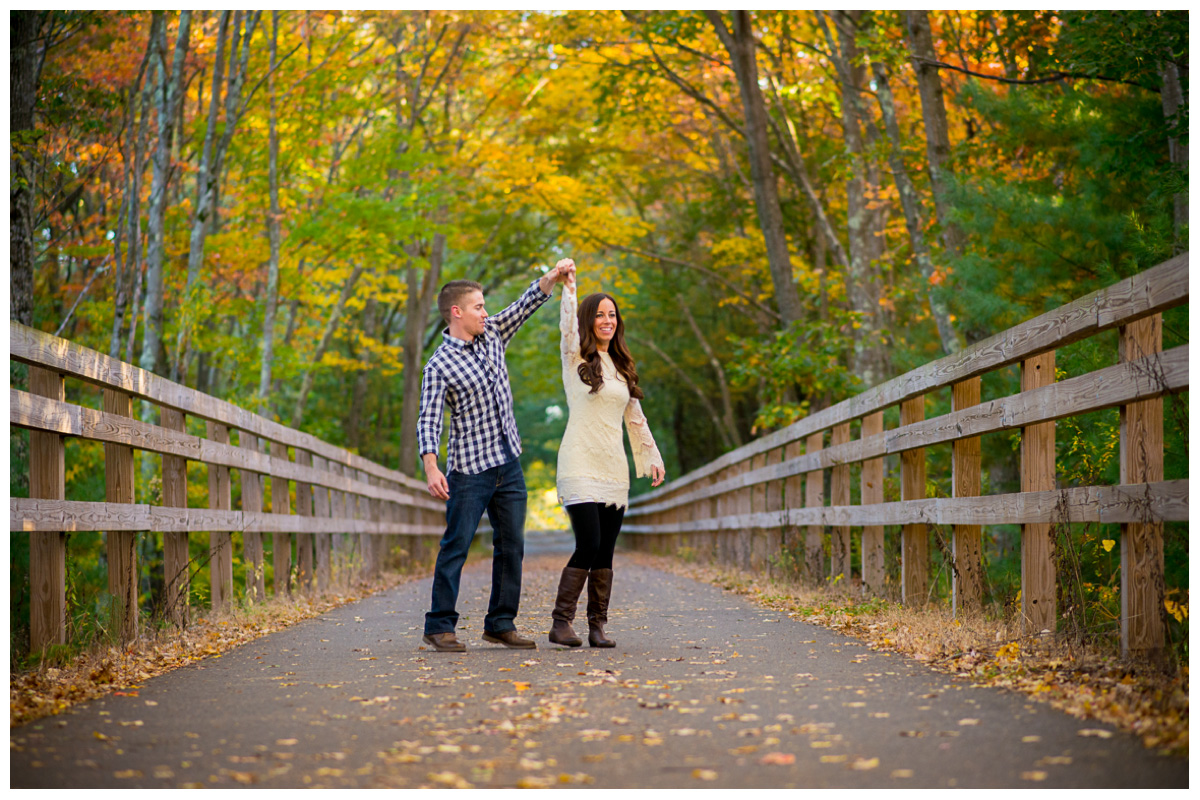 engaged couple dancing on trail during fall 