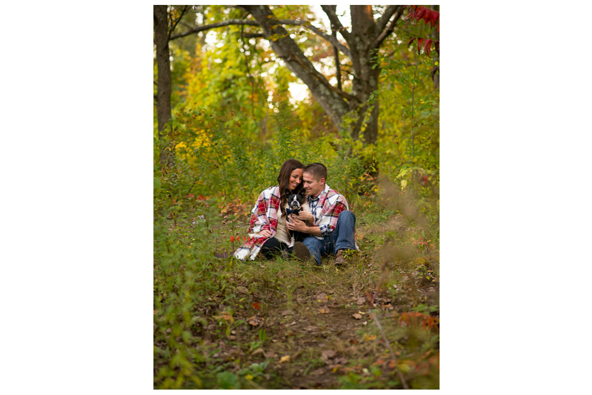 couple cuddled up with dog for engagement photos