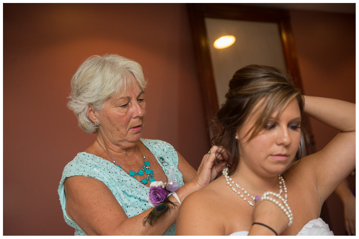 bride's mother putting on jewelry