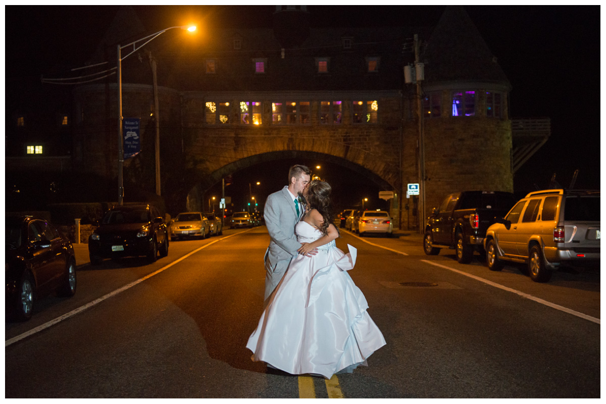 Bride and groom kissing at night in the middle of the street