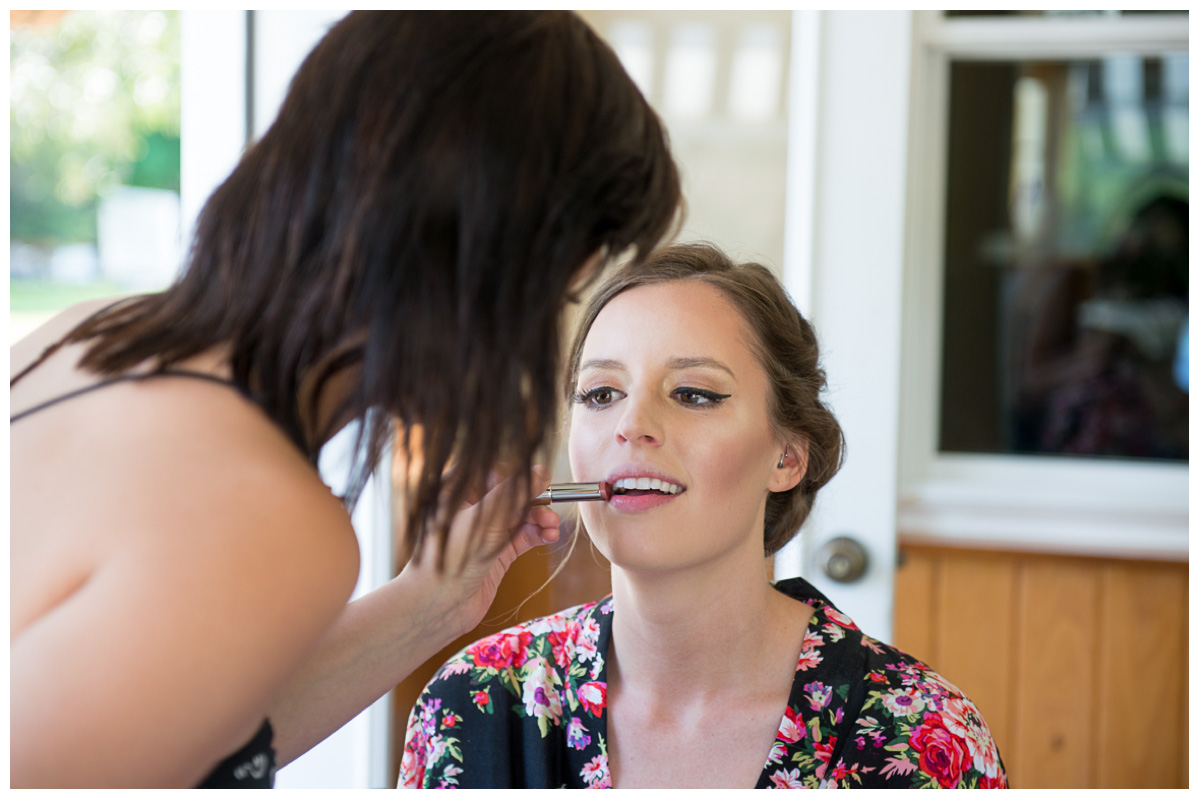 Bride in flower robe getting makeup done on wedding day
