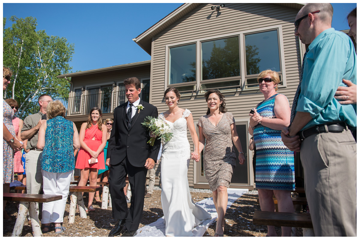 Bride walking down the aisle with mom and dad at a Maine private estate wedding