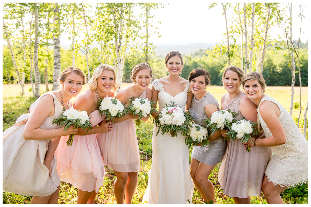 candid photo with bride with bridesmaids in light pink and tan dresses