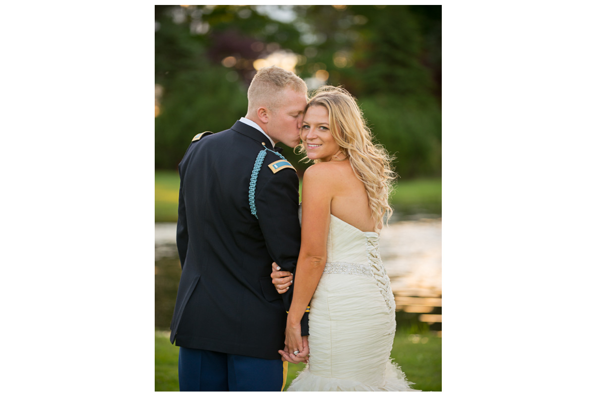 groom kissing bride's cheek during sunset