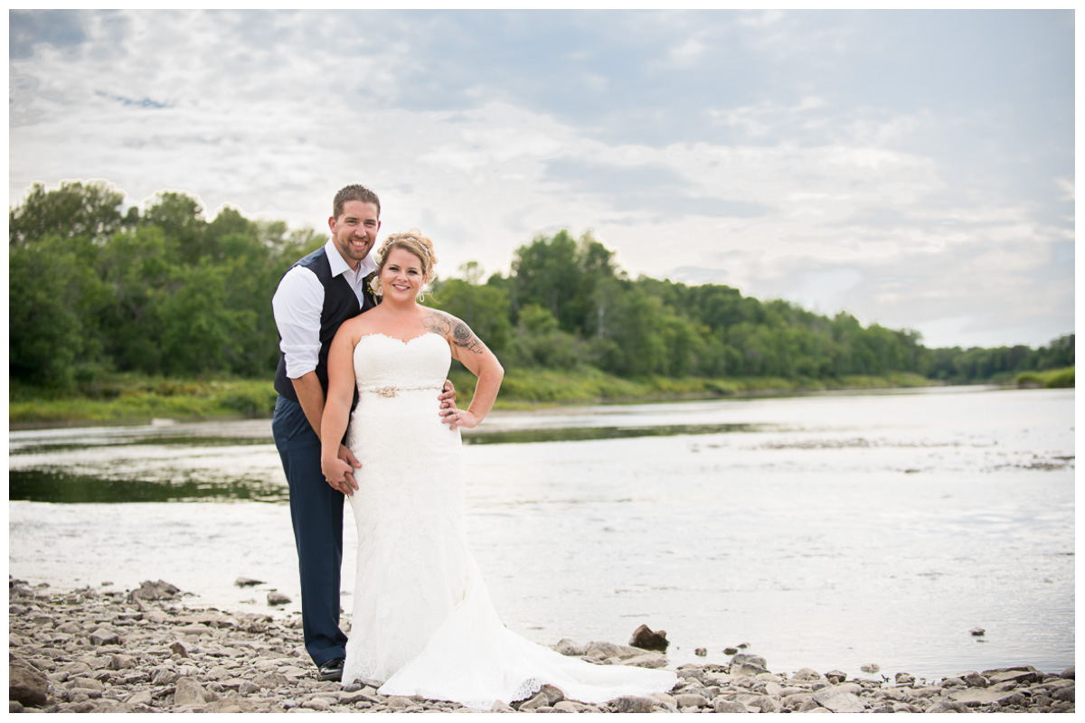 Bride and groom on riverbank in Maine