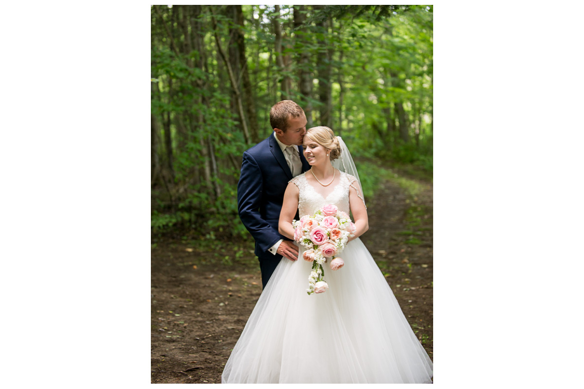 bride and groom in the forest on wedding day in Maine