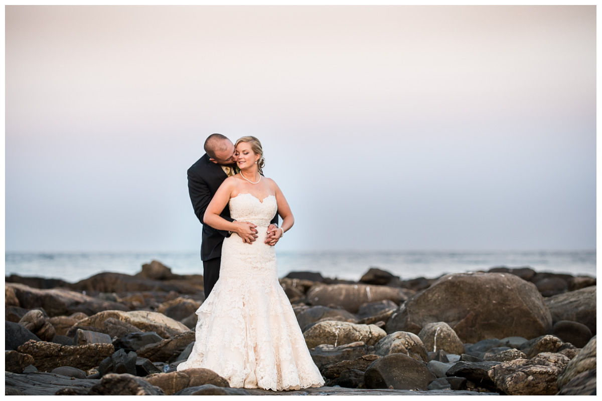 Happy married couple on beach at sunset with ocean 