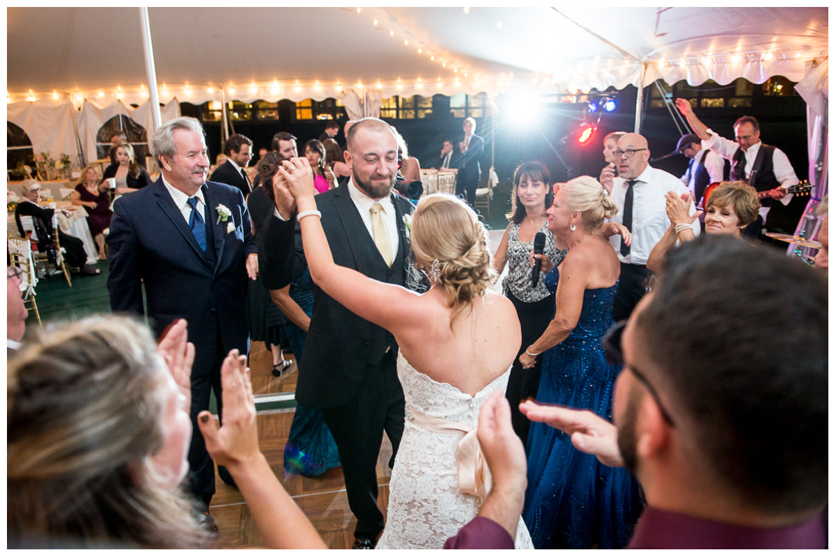 Wedding reception in white tent with guests dancing