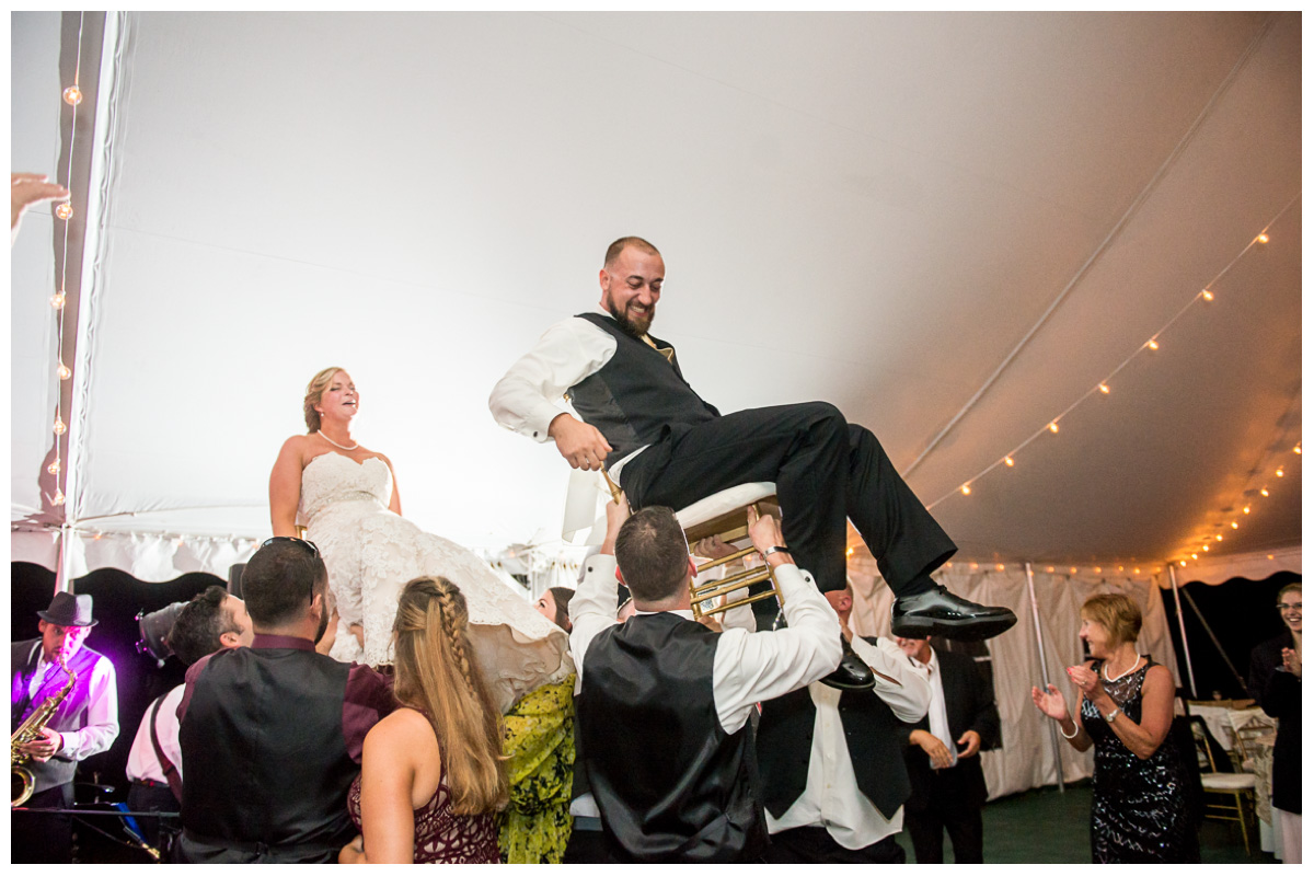 Bride and groom celebrating during wedding reception in white tent in New Hampshire