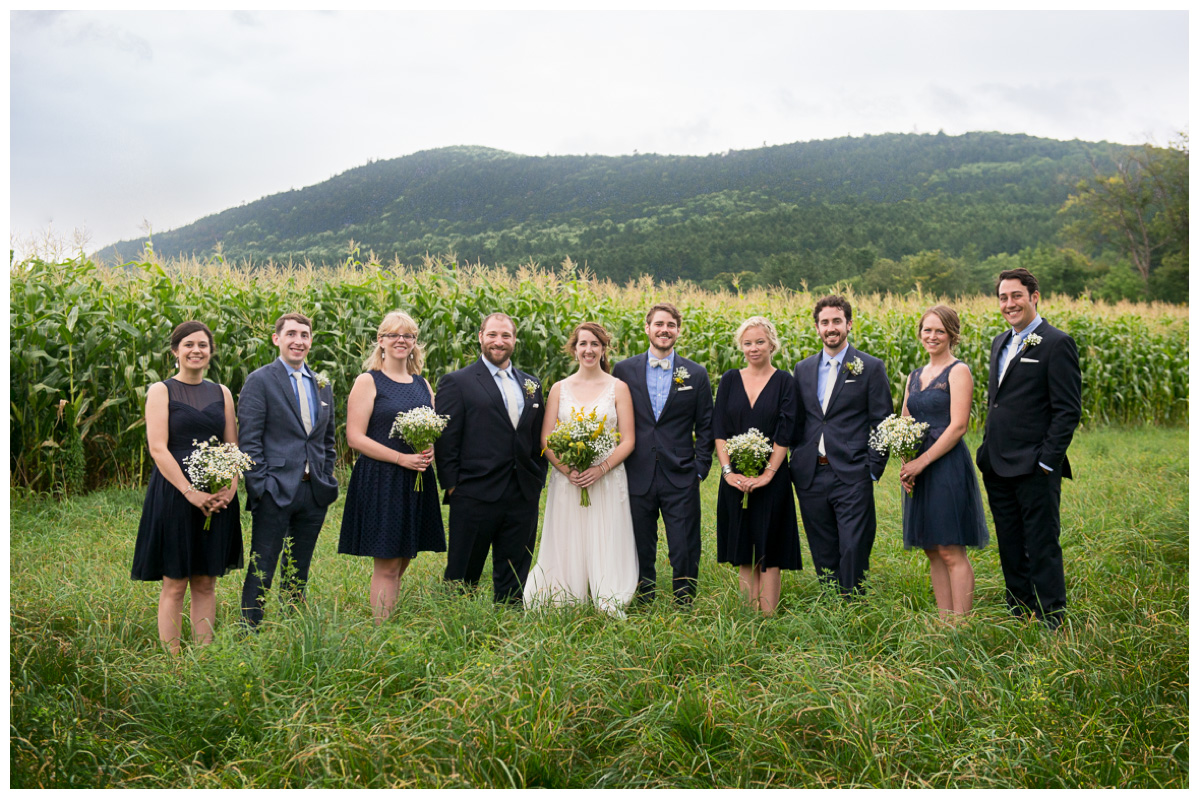 Bridal party in field in Vermont with Green Moutains