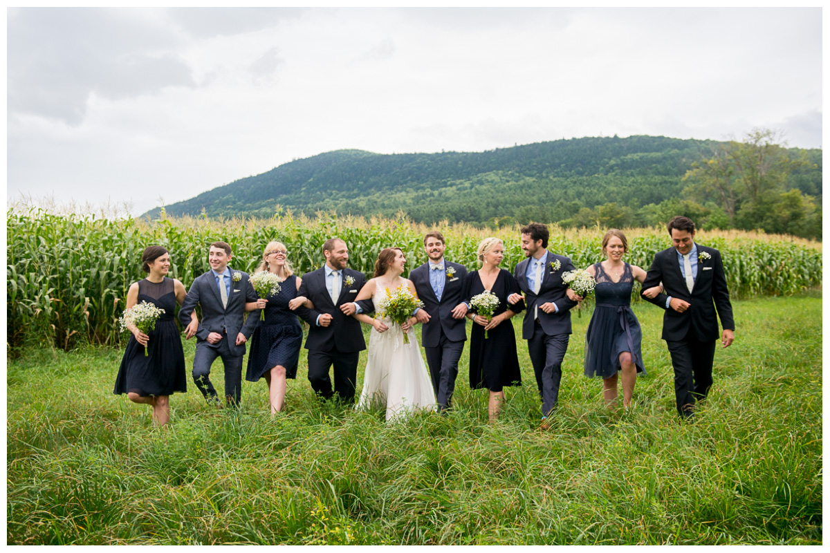 candid bridal party walking in field 