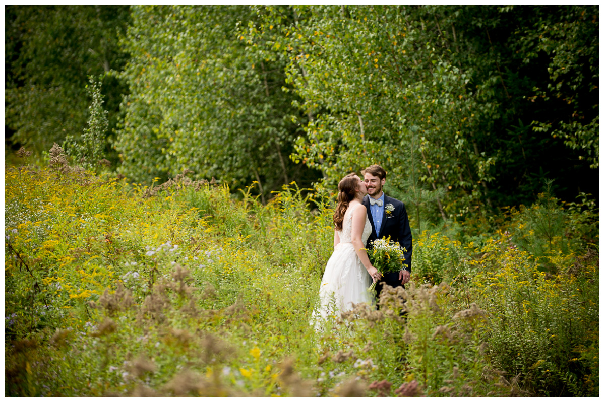 Bride and groom in field with wild flowers