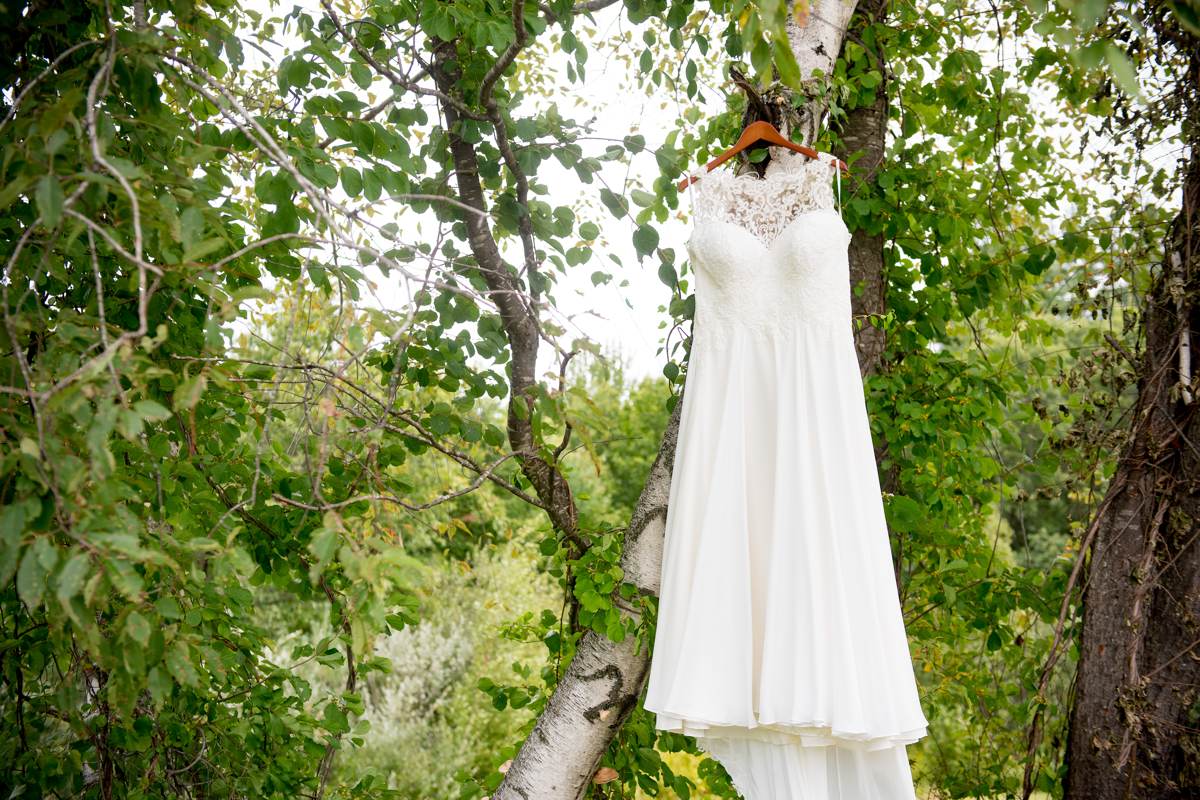 Hanging wedding dress in tree on wedding day