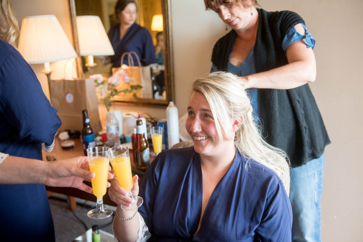 Bride getting ready with bridesmaids in robes and mimosas 